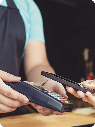 Pormenor de pagamento com telemóvel em terminal de pagamentos
